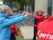 Ouderen sporten buiten onder begeleiding