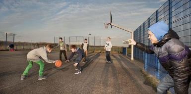Decoratieve foto van jongeren die basketballen op een plek die daarvoor bedoeld is
